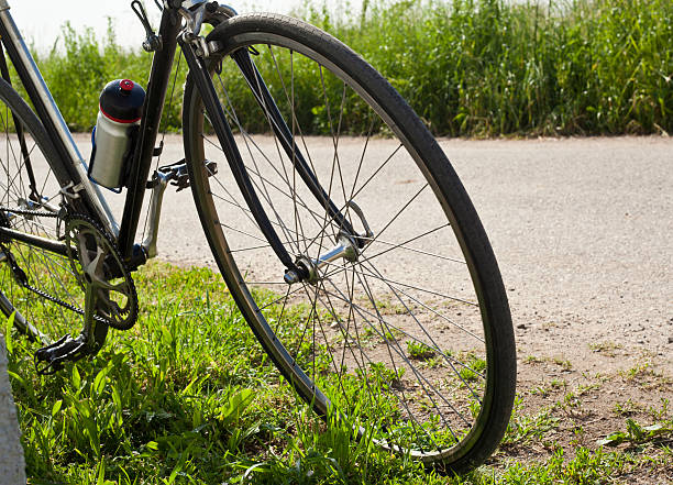 istock Bicycle Leaning With Road And Grass In The Background 171100253