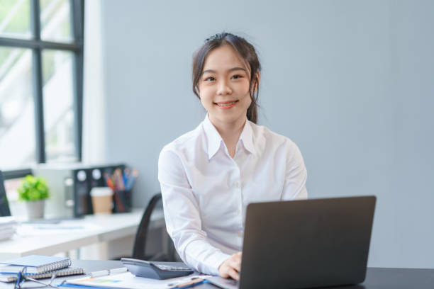 istock Successful Asian businesswoman smiling using laptop computer at office. Confident Asia businesswoman sitting happily in the office. 1711015244