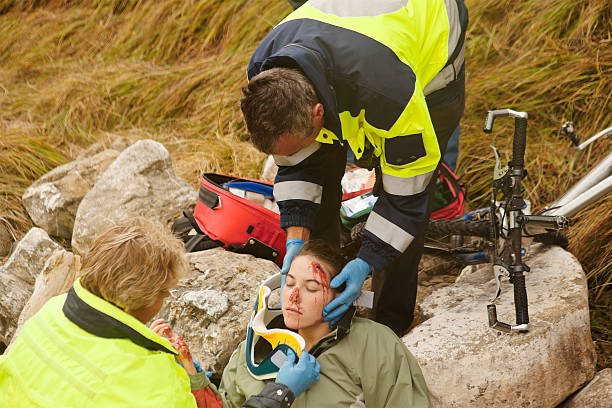 Emergency Response Team Attending Injured Woman Emergency response team attending to an injured woman after a bicycle accident in the Swiss Alps. Lenk Lypse 2012 triage stock pictures, royalty-free photos & images