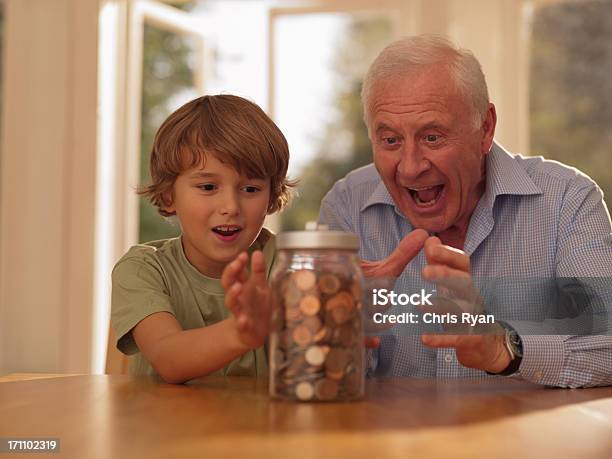 Abuelo Y Nieto Espera En El Frasco Lleno De Monedas Foto de stock y más banco de imágenes de 6-7 años