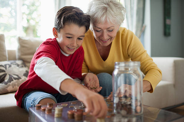 grand-mère et son petit-fils comptant pièces - wealth finance investment savings photos et images de collection