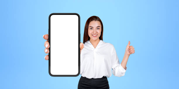 istock Cheerful thumb up woman showing smartphone with blank screen 1711028739