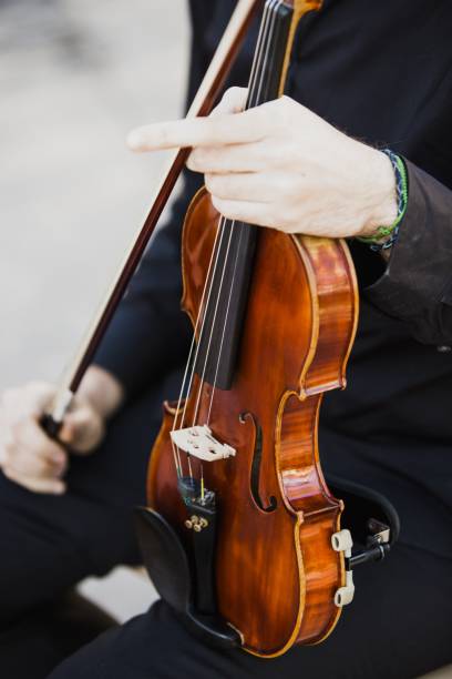 istock Classical musicians hold their musical instrument, a violin, while reading their score. 1711034610