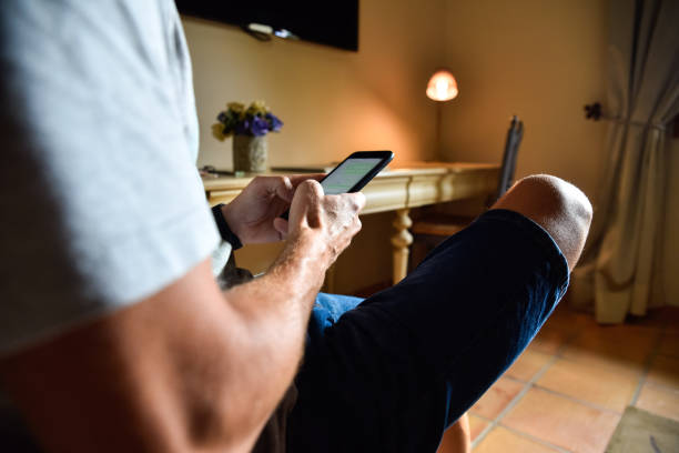 istock Man working remotely with his mobile phone in a hotel room. 1711037502
