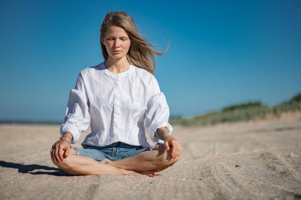 istock Girl practice meditation on the beach. With space for text or design 1711056556