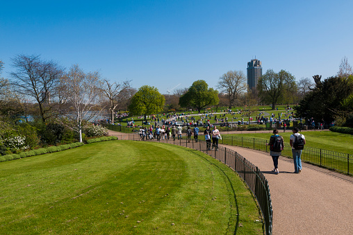 London, United Kingdom - April 17, 2010: People walk on a path through Hyde Park on a clear Spring day.