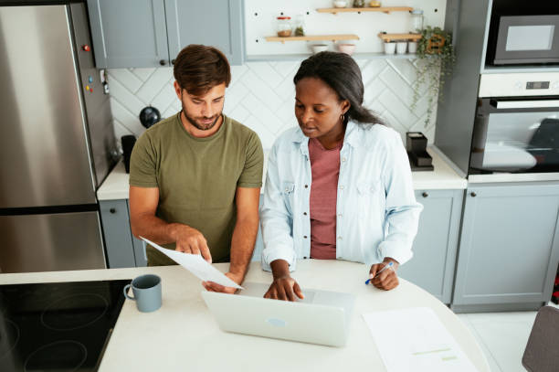 istock Multiracial couple at home using laptop 1711062732