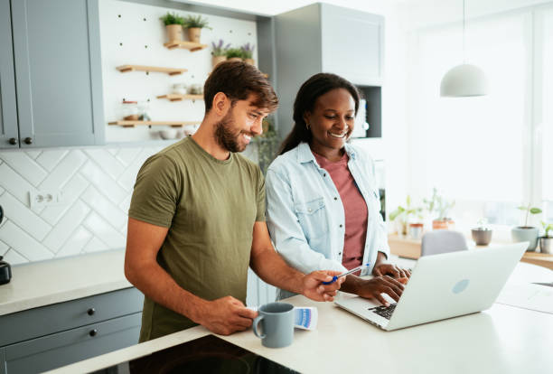 istock Multiracial couple at home using laptop 1711062755