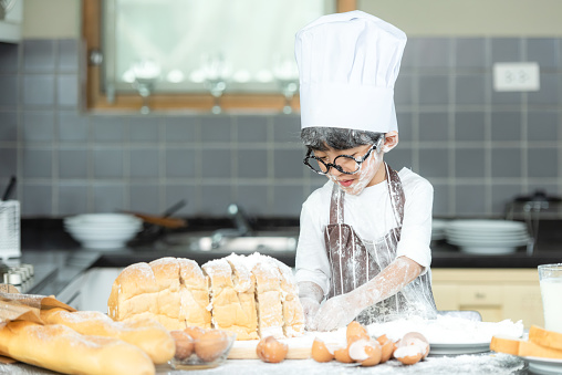 Cooking Family. Chef kid boy enjoy and funning cooking toast and make  bread with father.  Asian son help father making sweet food, so happy and education.  Family Lifestyle Concept