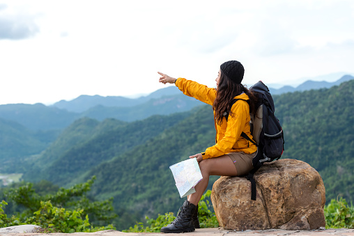 Woman travel hiker adventure on mountain nature landscape. Asia people lifestyle tourist girl backpack pointing find directions explore and camping outdoors for relax summer time. Travel Concept