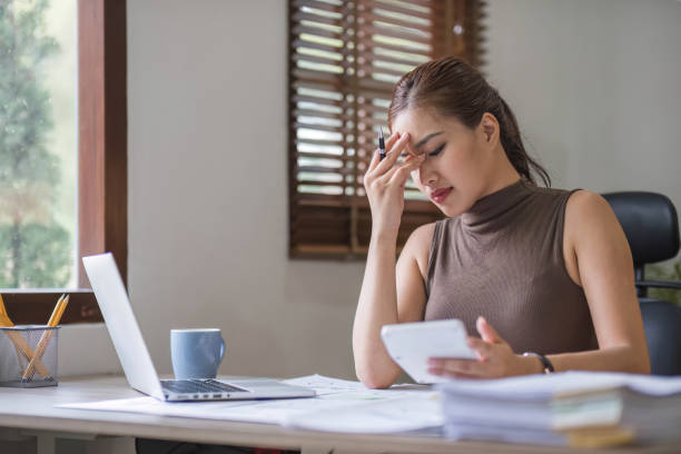 istock Young Asian businesswoman working on laptop computer, stressed has a headache and thinks hard from work at the office. 1711064079