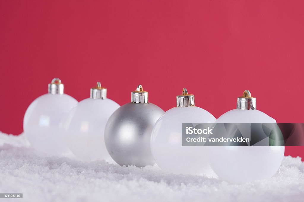 Christmas Baubles In Snow Studio shot of five old Christmas baubles lined up in the snow against a red background for copy. Celebration Event Stock Photo