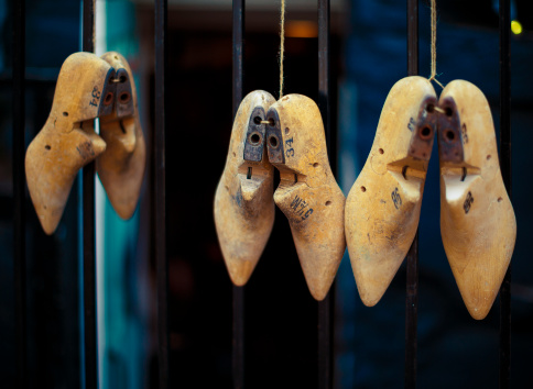 old wooden shoe molds of different sizes, hanging outdoors