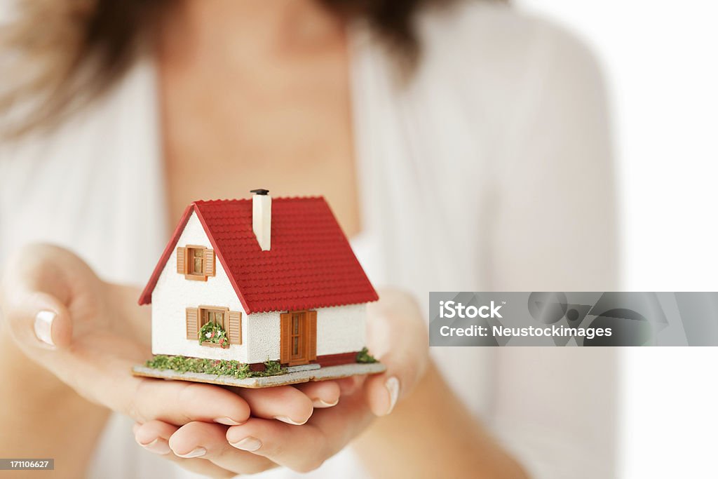 Femme mains tenant une petite maison-isolé - Photo de Maison de poupée libre de droits