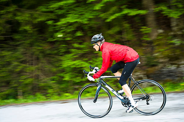 vista lateral do jovem ciclista masculina prática - racing bicycle cyclist sports race panning imagens e fotografias de stock