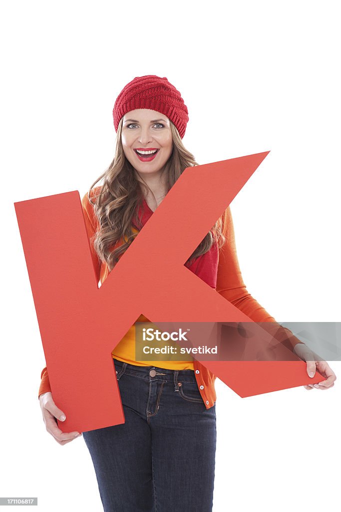 Woman holding letter K. Attractive woman in autumn clothes holding big 3D letter K and smiling at camera. Isolated on white. People with letters and numbers concept. Look for other images from this series. Click on image below for lightbox. Letter K Stock Photo