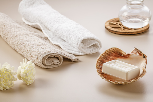 Fresh white towels with fir branch, candles and Christmas decorations. Skin care and body care. SPA massage or beauty salon, relaxation and self care in Christmas or New Year variant. Copy space.