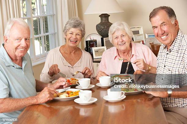 Group Of Senior Couples Enjoying Meal Together Stock Photo - Download Image Now - Senior Adult, Eating, Dinner