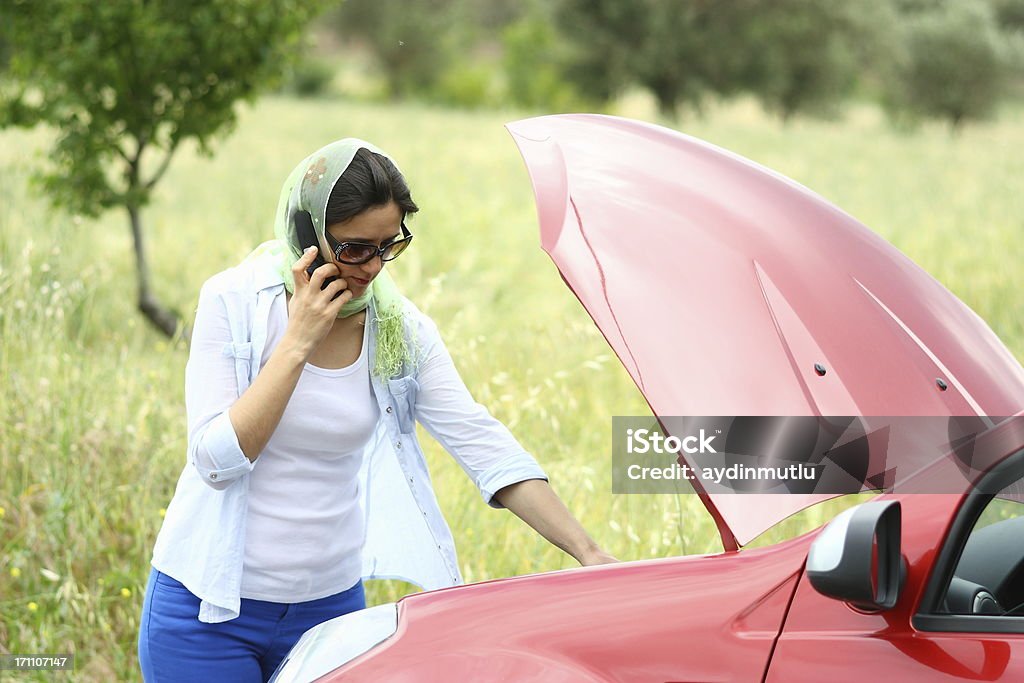 Car breakdown Women looking under the car hood. A Helping Hand Stock Photo