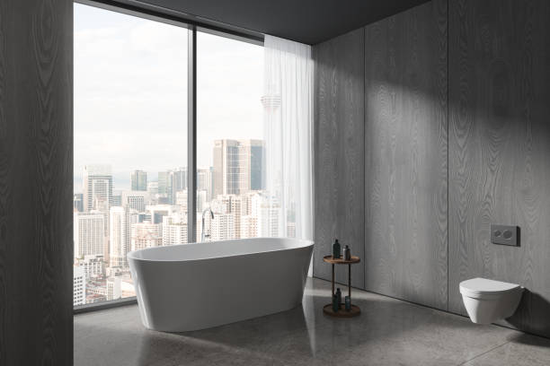 istock Grey home bathroom interior with tub and toilet, panoramic window 1711072624