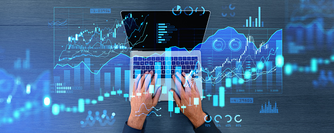 Man hands typing on laptop keyboard, top view. Forex hologram dashboard with diagrams and bar chart with candlesticks. Concept of online trading and big data analysis