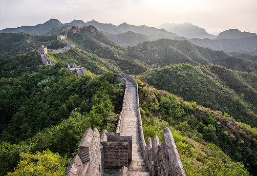 The Great Wall of China snakes across lush hills. This section is between Jinshanling and Simatai.