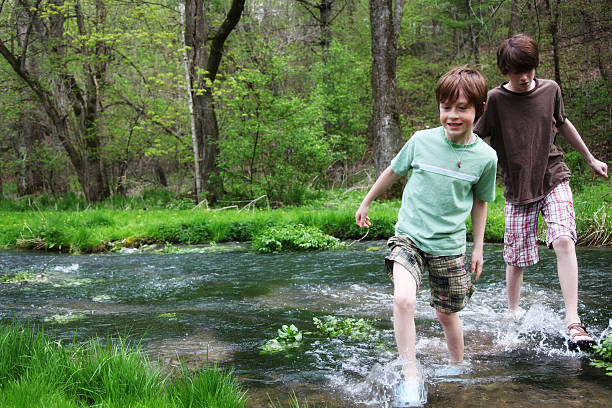 piccolo ragazzo giocare si increspa in legno stream- green park - parker brothers foto e immagini stock