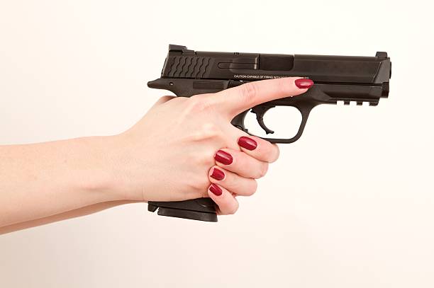 frau mit pistole, finger auf trigger - gun women handgun armed forces stock-fotos und bilder