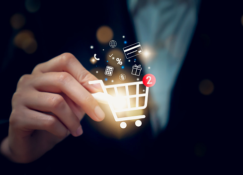 Businessman holding digital pen and touching on shopping cart icon.