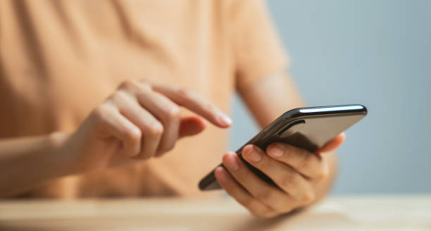istock Hand holding smartphone with using social media on internet on table. 1711080325