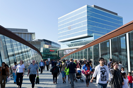 London, United Kingdom - March 28, 2012: Westfield Stratford City Shopping centre, situated next to the London Olympic site. Shoppers crossing a footbridge to the sprawling retail site, one of the largest urban shopping centres in Europe. The shopping centre is part of the Olympic Games redevelopment area, Stratford City. Westfield are an Australian shopping centre group.