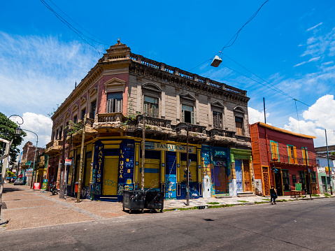 Buenos Aires, Argentina - December 15, 2009: Colourful buildings in the La Boca district. A woman can be seen walking on the street.