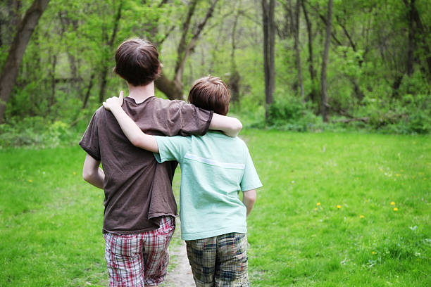 ragazzini cammina lungo il percorso in legno green park - parker brothers foto e immagini stock