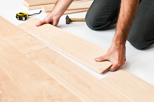 Close-up of man putting hardwood floor panels, floorboards stock photo