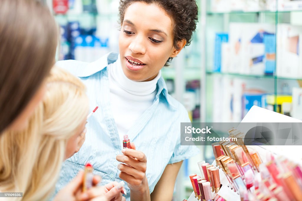 Women shopping for make-up products Two women shopping for make-up products at cosmetics store. Adult Stock Photo