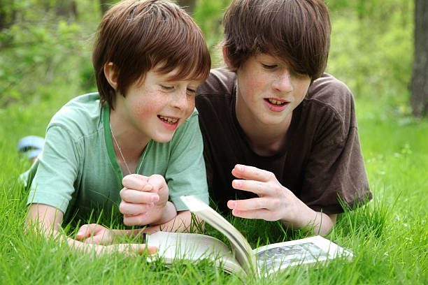 giovane ragazzo leggendo un libro di fuori - parker brothers foto e immagini stock