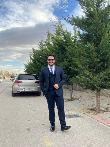 Photos of a Turkish businessman in a dark blue suit and blue tie
