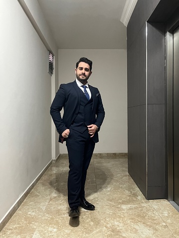 Photos of a Turkish businessman in a dark blue suit and blue tie