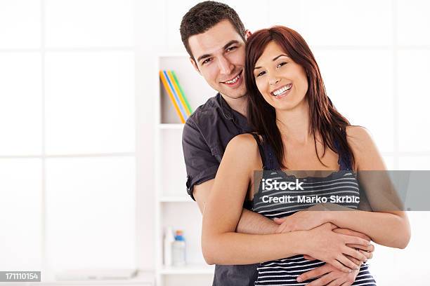 Sonriente Pareja En Casa Interior Foto de stock y más banco de imágenes de 20 a 29 años - 20 a 29 años, 25-29 años, Abrazar