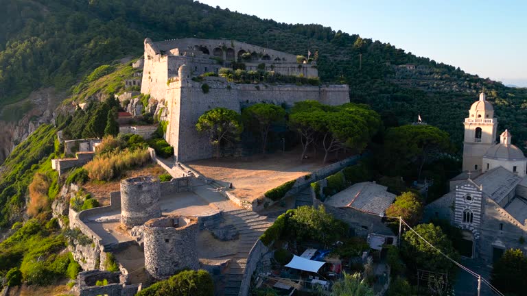 Aerial view of Chiesa di San Pietro and historic town, Sunset over mountaintop in Lerici, famous Church of Saint Peter in Porto Venere, Panoramic View of Gothic Church of St. Peter and Byron's Grotto in Porto Venere, Doria Castle