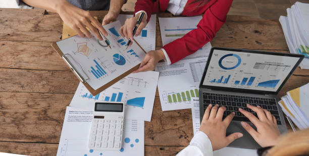 istock Business People Meeting using laptop computer,calculator,notebook,stock market chart paper for analysis Plans to improve quality next month. Conference Discussion Corporate Concept. 1711104631