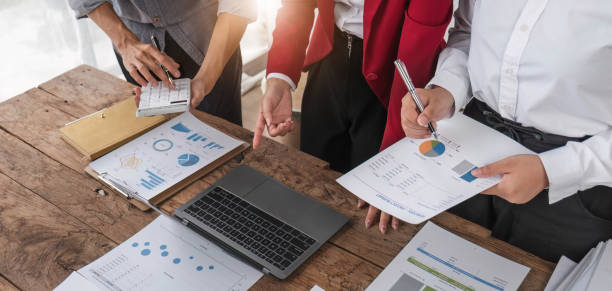 istock Business People Meeting using laptop computer,calculator,notebook,stock market chart paper for analysis Plans to improve quality next month. Conference Discussion Corporate Concept. 1711105262
