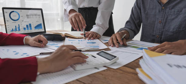 istock Business People Meeting using laptop computer,calculator,notebook,stock market chart paper for analysis Plans to improve quality next month. Conference Discussion Corporate Concept. 1711106365