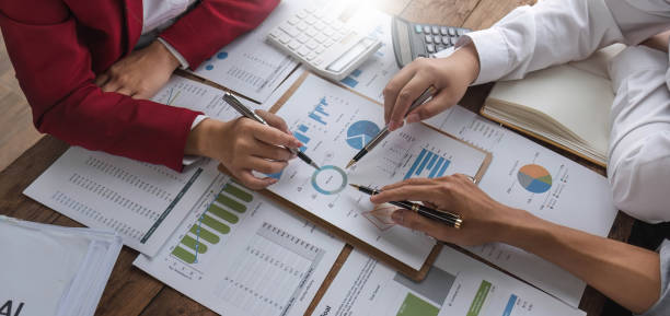 istock Business People Meeting using laptop computer,calculator,notebook,stock market chart paper for analysis Plans to improve quality next month. Conference Discussion Corporate Concept. 1711106980
