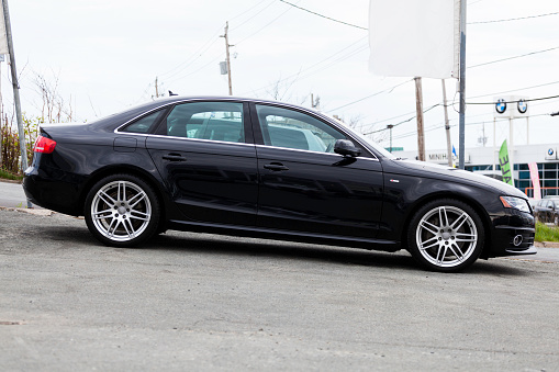 Halifax, Nova Scotia, Canada - May 13, 2012: The side view of an Audi A4 on a car dealership lot.  Vehicle is on a downward slope and behind and in background, a BMW dealership is visible.  The Audi A4 is an executive sedan first manufactured in 1994.  It is currently in its fourth generation (as of May 2012).