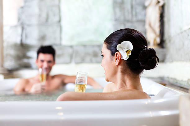 casal relaxando na banheira de hidromassagem no spa - couple hot tub spa treatment health spa - fotografias e filmes do acervo