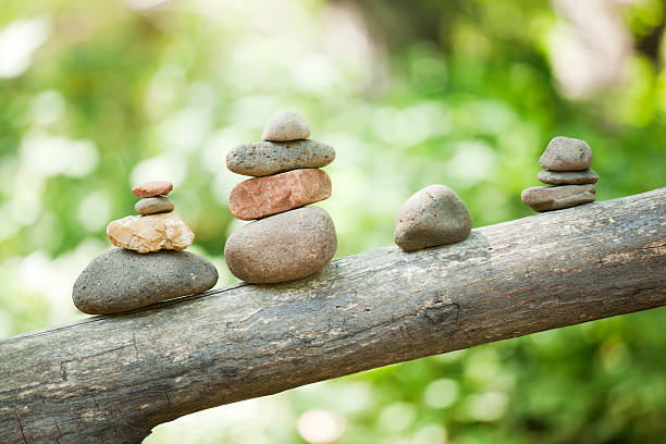 Pebble stone cairns resting on a fallen tree branch near Buddha Beach of Red Rock Crossing day use park area. People pile these rocks as a meditation and for making wishes. Red Rock Crossing is near Sedona, Arizona, U.S.A.