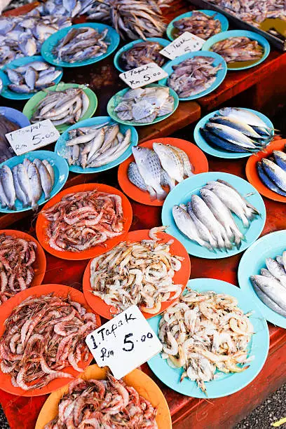 Kuching, Malaysia - March 3rd, 2012 : fresh fish neatly arranged on colourful plates at the Kuching sunday market.