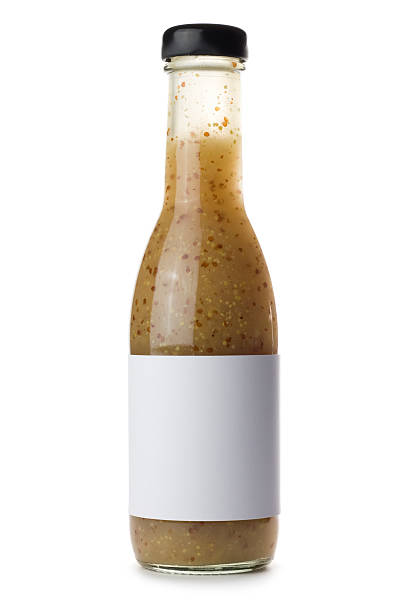 Glass bottle of salad dressing isolated on a white background A bottle of salad dressing with a blank label isolated on a white background. bottle of salad dressing stock pictures, royalty-free photos & images