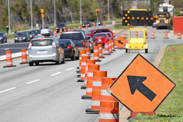 All Traffic Move Left Signs A standard move left sign and a digital flashing arrow with traffic cones advises all traffic to move into the left lane. Shot shallow dof with focus on foreground arrow sign. traffic cone photos stock pictures, royalty-free photos & images